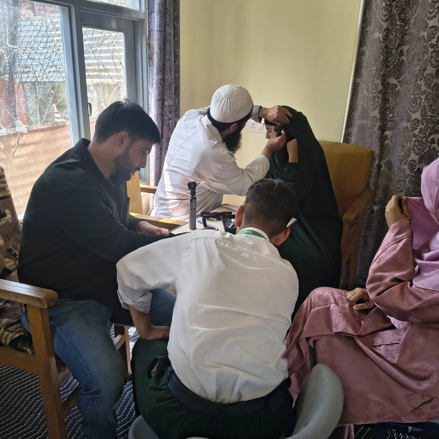 An ENT clinician examining a student's ear at Abhedananda Home