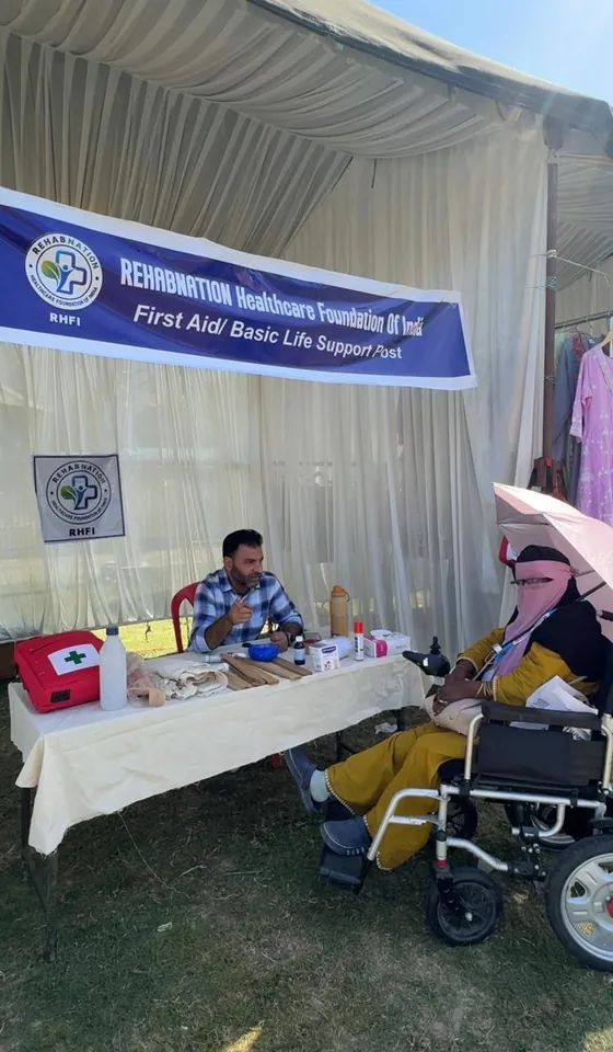 RehabNation's First Aid and Basic Life Support post at EMERGE, SKICC, with a visitor beside the team