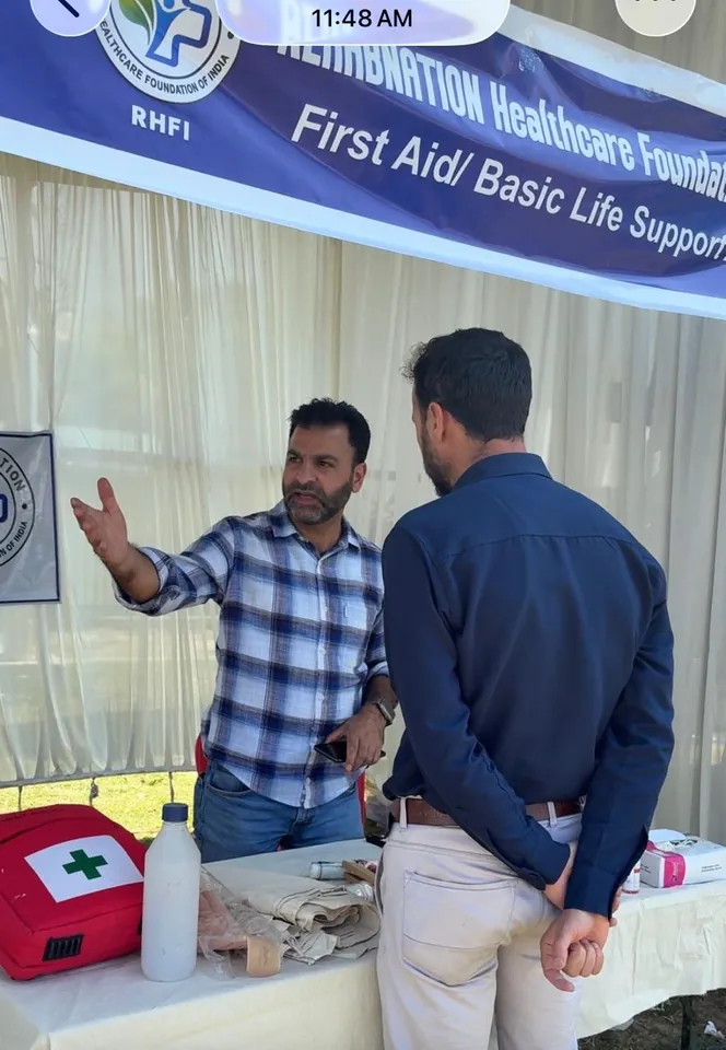 A RehabNation team member demonstrating a first-aid technique to a visitor at EMERGE, SKICC